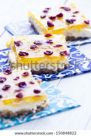 Hawaiian pineapple bars made with a graham cracker crust, cream cheese and marshmallow filling, jello and crushed pineapple topping, and sprinkled with dried cranberries