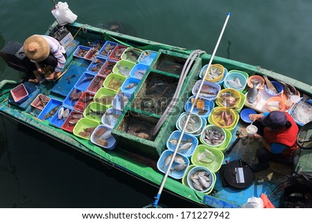 Floating Fish Market. Unusual assortment of fresh fish for sale. One of the fisherman is taking a lunch break.