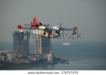 Penang Hill Fire. 26th February 2014, Fire fighting plane preparing to put out the jungle fire. Angled profile of the Malaysian Maritime aircraft as it overflies tower blocks in Penang.