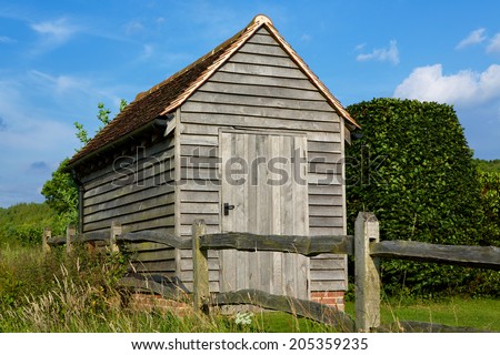 Garden Shed. Traditional lap wood shed found in many gardens. Set in the corner of a garden on a summers day.
