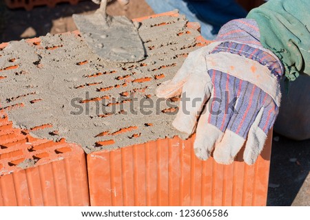 Bricks and plaster. Closeup of some bricks at a construction site involving plastering with a trowel