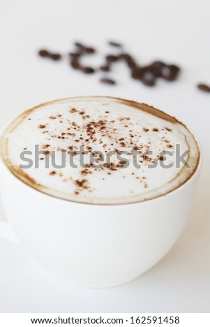 Hot coffee with coffee bean in sun light on white table
