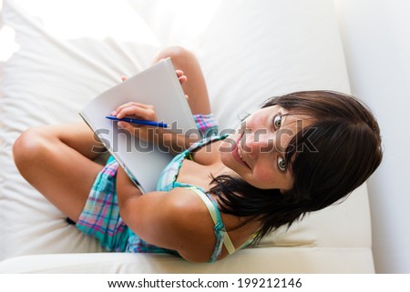 happy young woman holding a writing pad