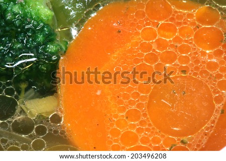 macro nourishing delicious soup with broccoli and carrots in a white plate