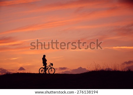 Silhouette of man and mountain biking in the sunrise