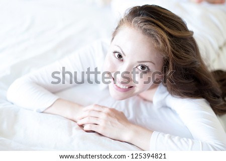 Attractive Asian Mixed Woman smiling in bed looking up