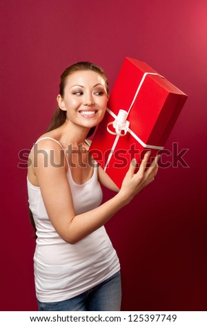 Attractive Asian Mixed Woman finding out what is inside the gift box