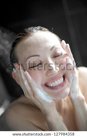 Attractive Mixed Asian Female in the shower washing her face