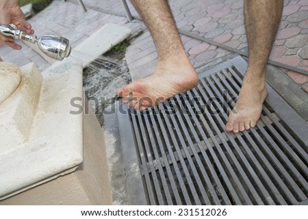 Male model washing feet at pool lake