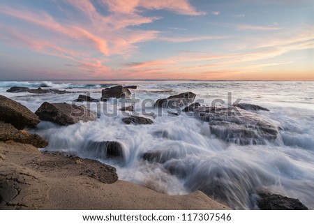 Waves crashing on rocky beach. This is an image of waves crashing on the rocks of a beach in Southern California at sunset.