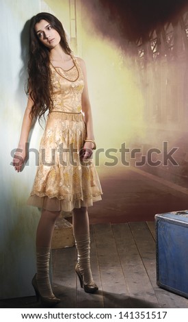 Full length image of an attractive young girl posing on wooden floor