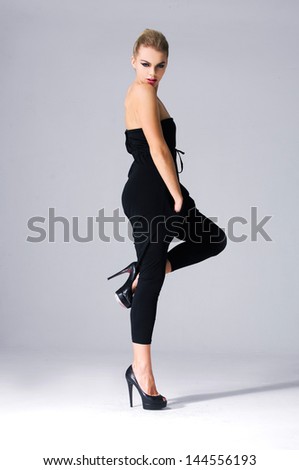 Full body portrait of beautiful sexy Caucasian young stylish woman model in black dress