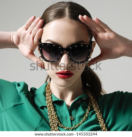 closeup portrait of young gorgeous caucasian woman wearing sunglasses with hands on face