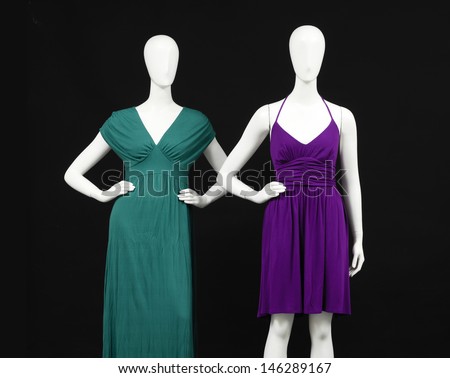 Mannequin dressed in red and green sundress on black background
