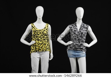 Two mannequin dressed in fashion shirt and trousers on black background