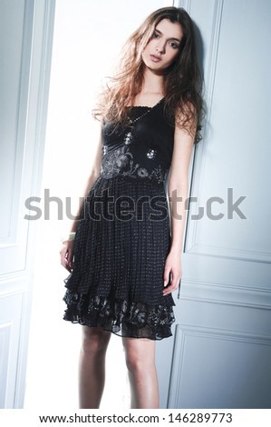 young fashion model posing standing and looking in camera