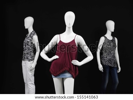 Three mannequin dressed in shirt and trousers on black