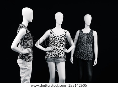 black and white mannequin dressed in shirt and trousers on black background