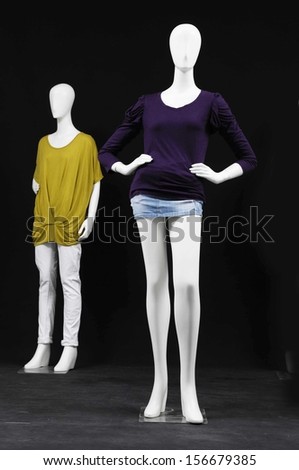 Two mannequin dressed in fashion shirt and trousers on black background