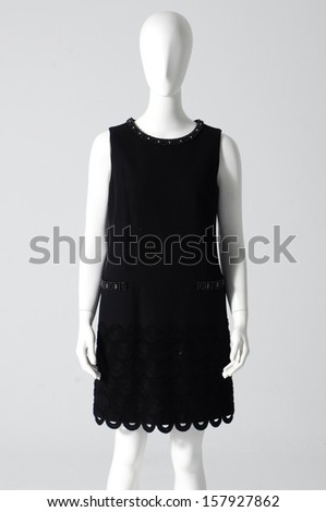 Mannequin dressed in black dress on gray background