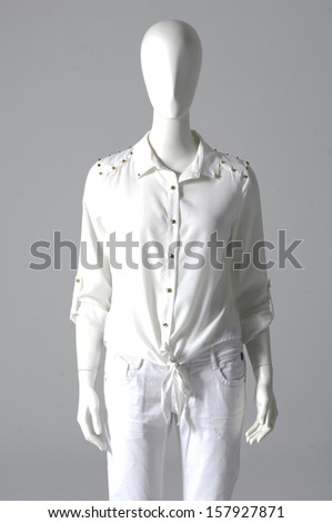 Mannequin dressed in shirt with trousers on gray background