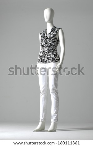 full-length mannequin dressed in shirt and white trousers on gray background
