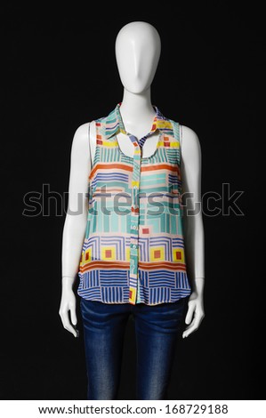 female mannequin dressed in fashion shirt and jeans on black background