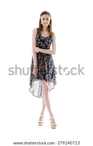Full body beautiful young fashion model in evening gown walking in studio