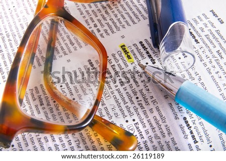 Dictionary page closeup with the word Easter and brown glasses on it
