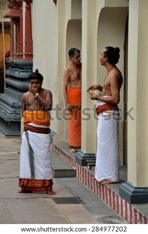 Singapore - January 12, 2013: Three Hindu priests seen at Singapore\'s oldest Hindu temple, Sri Mariamann. The temple is located in the city\'s Chinatown district and primarily serves Tamil Hindus.