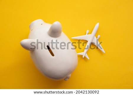 Holiday flight fare saving concept. Piggy bank with a toy plane. Vacation budget planning Stock foto © 