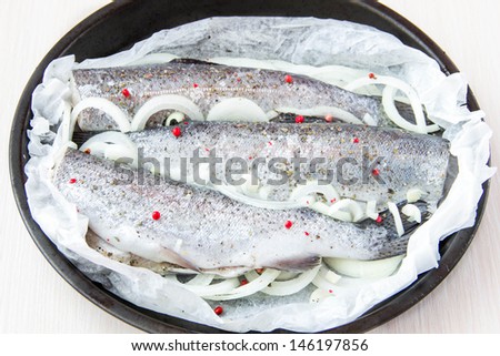 Raw fish rainbow trout prepared for baking in frying pan