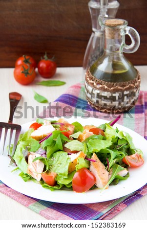 Delicious fresh salad with salmon, lettuce, cherry tomatoes and herbs, restaurant appetizer, tasty food