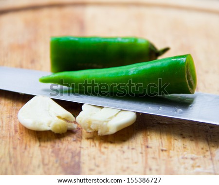 Cut in half green chilli pepper and crushed garlic clove