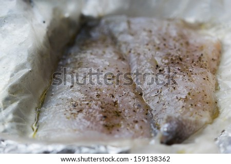 Two fillets of white fish perch marinated in herbs and oil