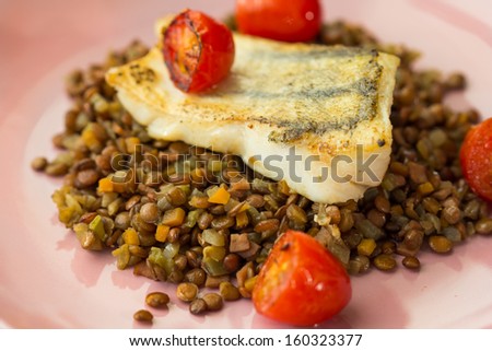 White fish fillet of perch, cod with vegetables and lentils, tomatoes, tasty dish