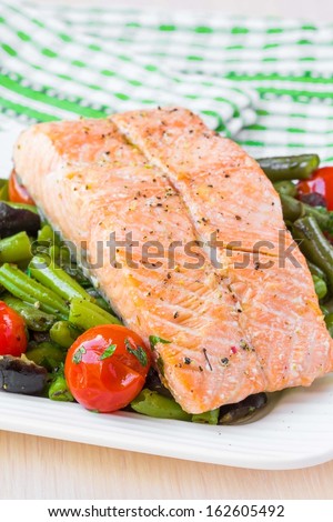 Fillet of red fish salmon with green beans, tomatoes and black olives, tasty diet dinner