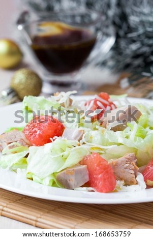 Tasty fresh salad with grapefruit, chicken, lettuce, cheese and sauce, Christmas appetizer
