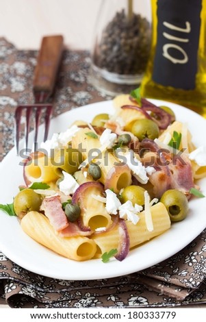 Rigatoni pasta with bacon, green olives, feta cheese, red onion, capers, italian delicious homemade dinner