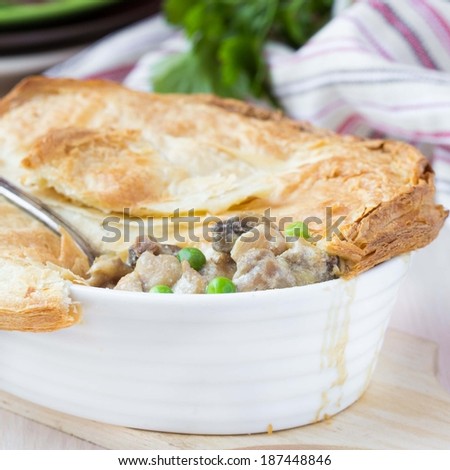Meat pie with stew of chicken, mushrooms, peas, puff pastry crust, tasty homemade dish