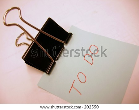 Binder clip holding blue note with the words \