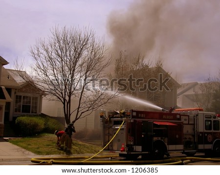 Fire truck and firemen at scene of house fire #29
