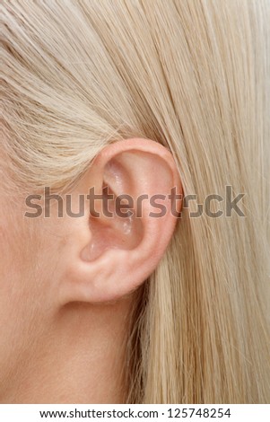 A close-up of the ear of a young blonde female.