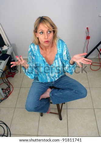 A lovely blonde sits amidst clutter indoors with an \