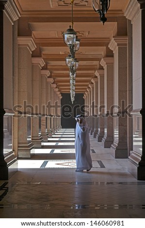 ABU DHABI, UAE - MARCH 17, 2010: Man walking outside of Emirates Palace hotel on March 17, 2010. Emirates Palace is a luxurious and the most expensive 7 star hotel designed by John Elliott RIBA.