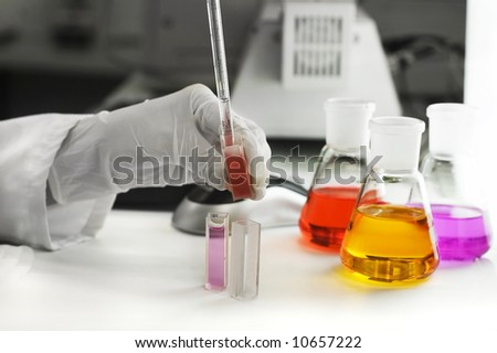 hand holding laboratory flasks and computer mouse