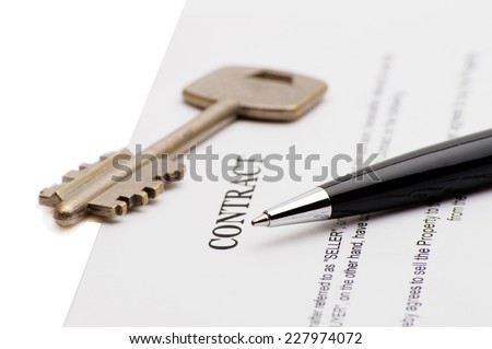 Close-up of pen on contract and key
