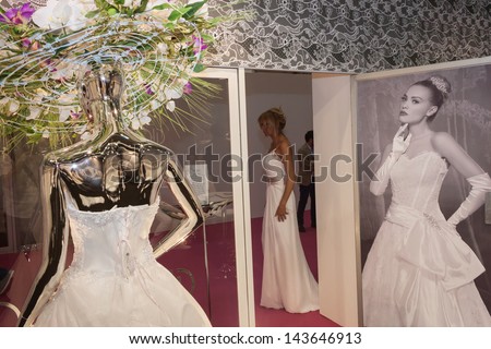 MILAN, ITALY - JUNE 21: Model and mannequin with wedding dress at SposaItalia, international exhibition of bridal and formal wear according to Italian style, on JUNE 21, 2013 in Milan