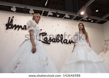 MILAN, ITALY - JUNE 21: Models with wedding dresses pose at SposaItalia, international exhibition of bridal and formal wear according to Italian style, on JUNE 21, 2013 in Milan