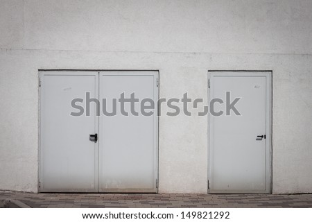 Two external shut doors on a white wall